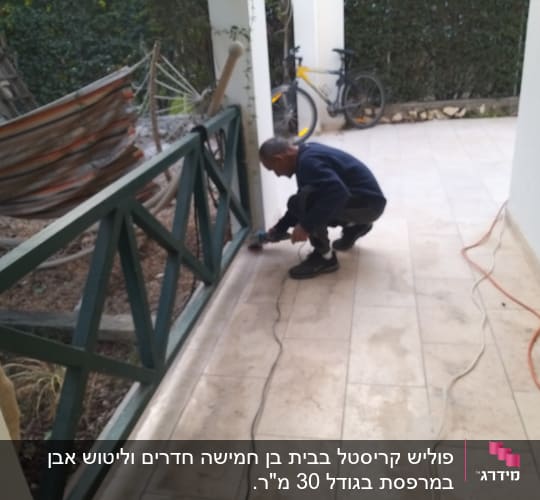 אדם מנקה רצפה עם מכשיר חשמלי במרפסת
